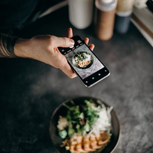 person taking photo of dish in bowl